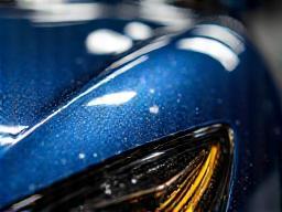 Close-up of painted car surface with transparent ceramic coating applied for protection